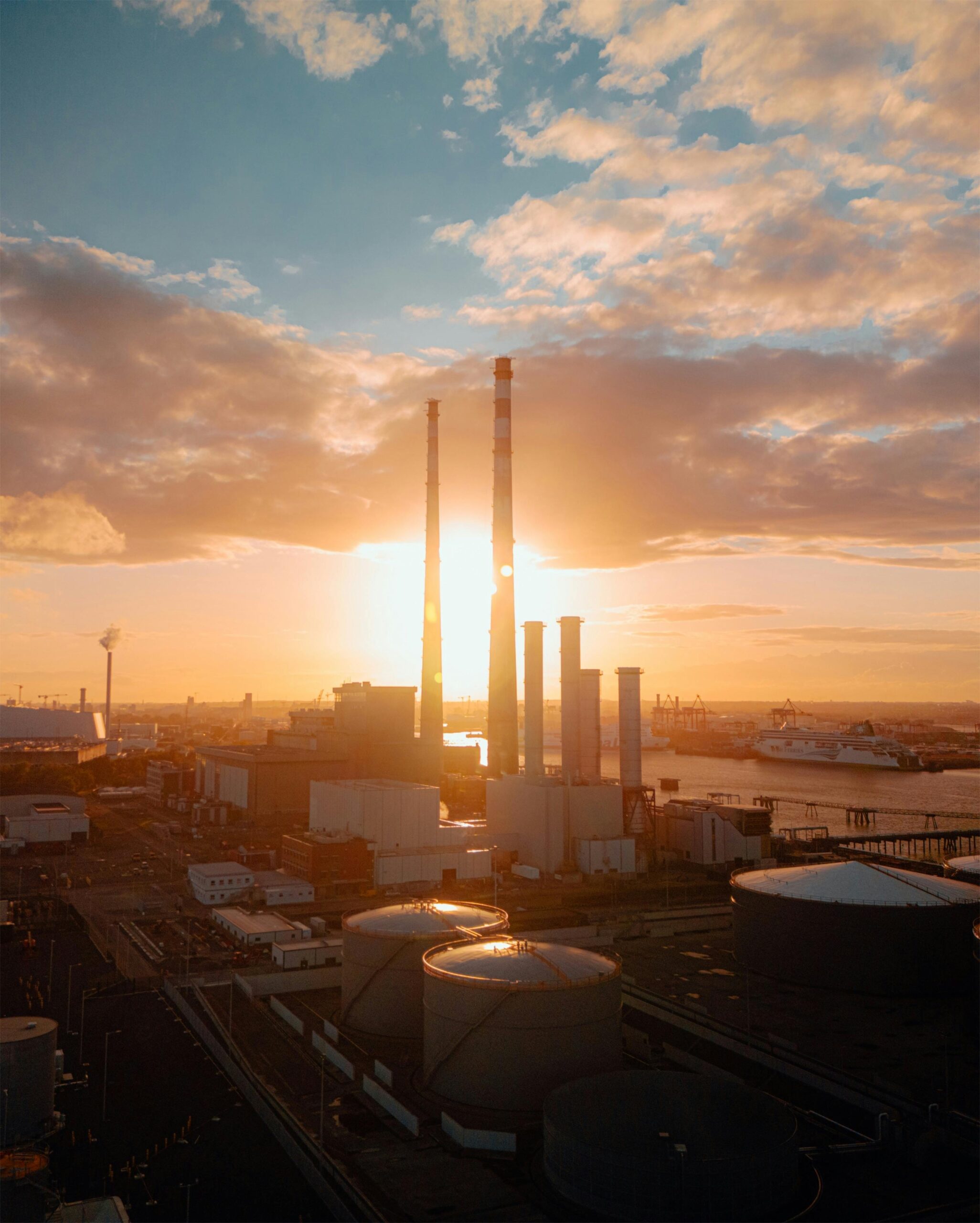 Aerial view of Dublin's industrial area at sunset, showcasing chimneys and the River Liffey.